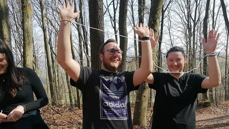 Foto: Katja Sander: Die Teilnehmer sind mit Freude bei den Kooperationsspielen im Wald dabei.